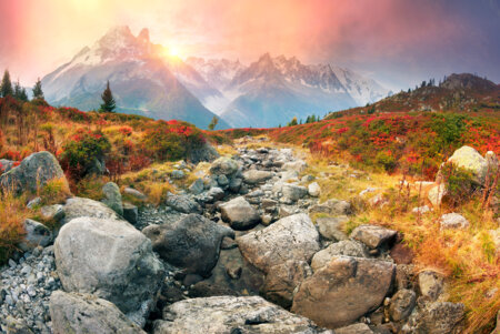 Sublime paysage automnal avec un coucher de soleil derrière les montagnes enneigées des Alpes