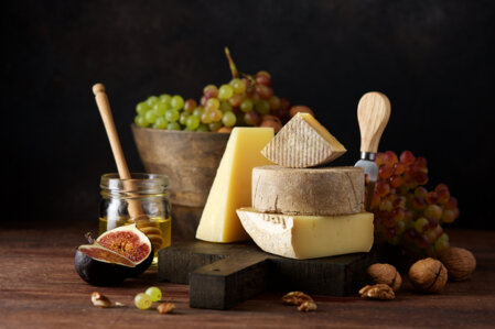 Plateau de fromages savoyards à déguster avec des noix, du miel, des figues et des raisins