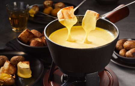 Two pieces of bread are immersed in a Savoyard fondue